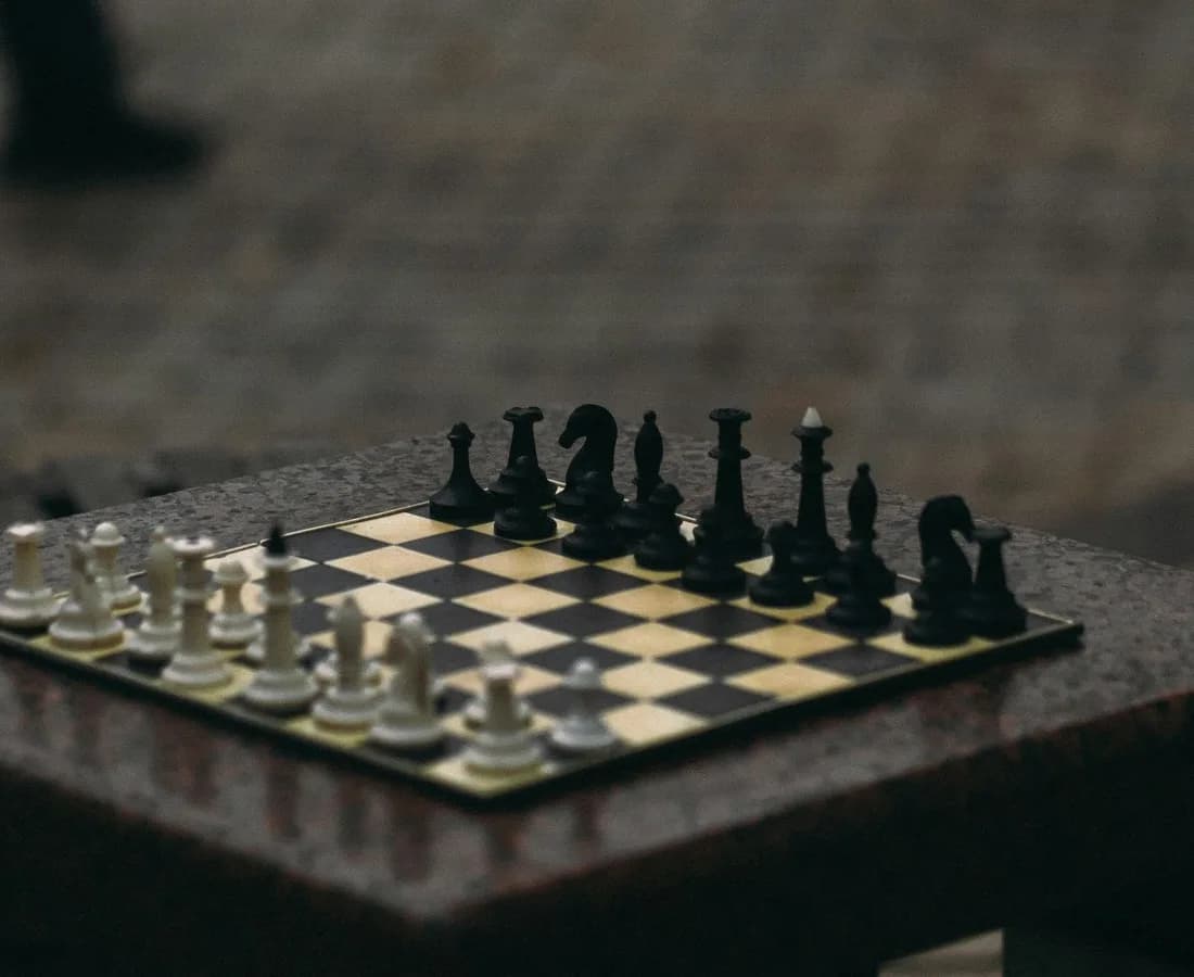 Échiquier installé sur une table de pierre, pièces en position de départ