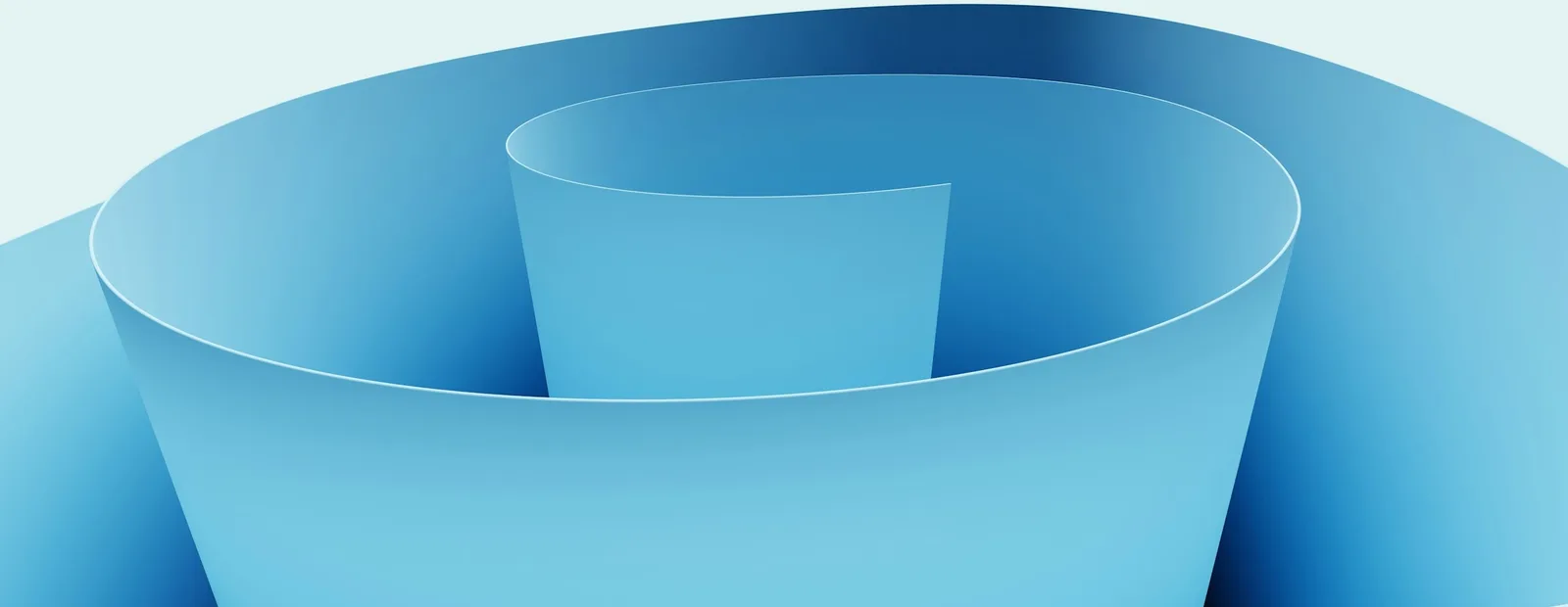 Spirale de papier bleu enroulée sur elle-même, sur un fond bleu très pâle.